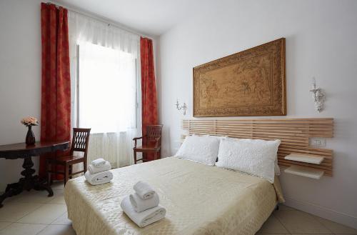 a bedroom with a bed with two towels on it at LE CAMERE di VITTORIA in Bracciano