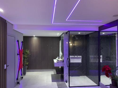 a bathroom with a purple ceiling with a shower and a sink at Motel Cristal in Araras