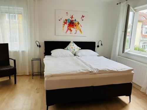 een slaapkamer met een groot bed met witte lakens bij Entzückende kleine Vorstadtvilla in Klosterneuburg