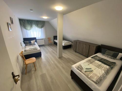a bedroom with two beds and a table and a chair at Apartments Feniks in Blomberg