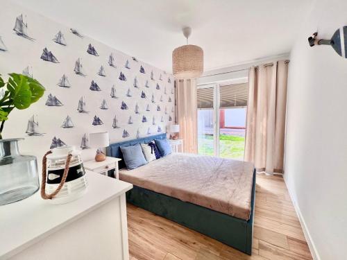 a bedroom with a bed and a wall with boats on it at Luksusowy Apartament 2A-3 in Żarnowska