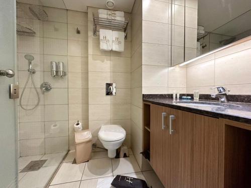 y baño con aseo, lavabo y ducha. en Hayali Suites en Jounieh