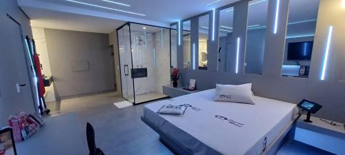 a bedroom with a large white bed and a mirror at Motel Cristal in Araras