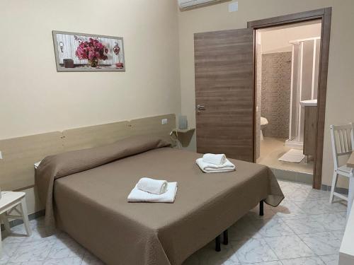 1 dormitorio con 1 cama con toallas en Bed and Breakfast Rio Casaletto, en Casaletto Spartano