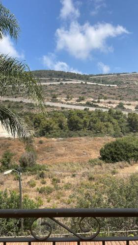 een uitzicht op een veld vanaf een bank bij במורד ההר in Shelomi