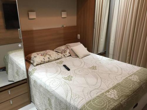 - une chambre avec un lit et un miroir dans l'établissement TOP DA PRAIA - 2qts, ar cond, WIFI, cozinha, garagem , completo, à Vila Velha