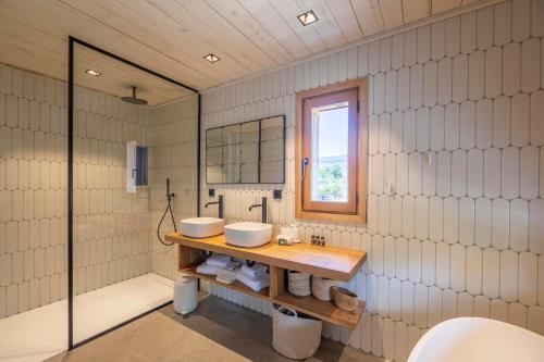 a bathroom with two sinks and a window at Hôtel du Domaine Casanghjulina in Porto-Vecchio