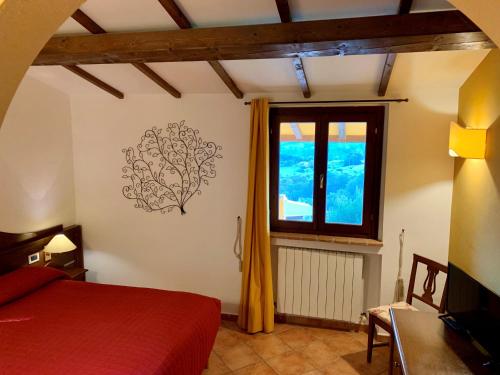 a bedroom with a red bed and a window at Agriturismo San Felicissimo in Ponte Felcino