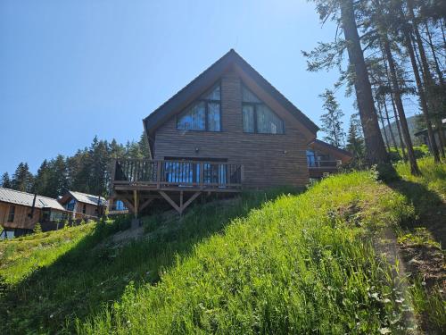 a log house on a hill with a deck at Chata Paja in Liptovský Mikuláš