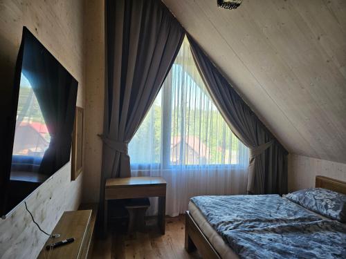 a bedroom with a bed and a large window at Chata Paja in Liptovský Mikuláš