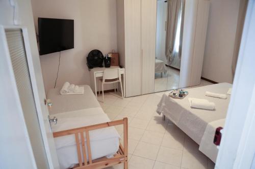 um pequeno quarto com uma cama e um espelho em Guest House Malaguzzi em Reggio Emilia