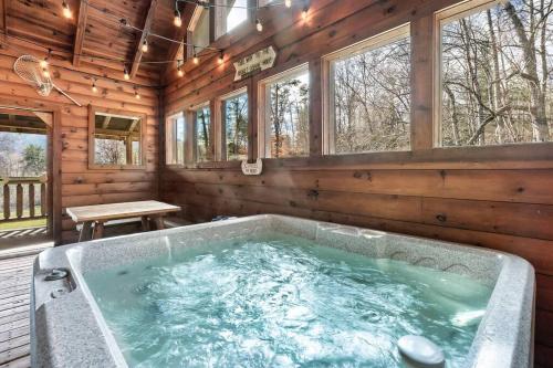 eine Whirlpool-Badewanne in einem Blockhaus in der Unterkunft Spectacular MTNS Views with PRIVATE HOT TUB with Pool Table and Private Pond in Sevierville