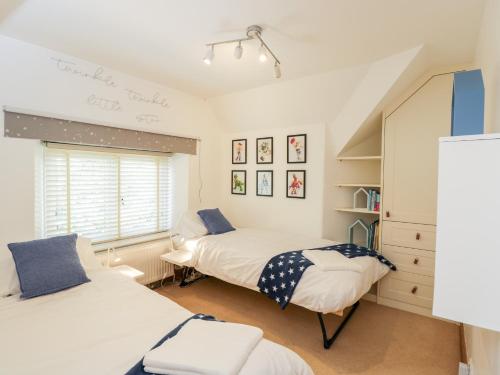a bedroom with two beds and a window at 2 Dewars Farm Cottages in Bicester