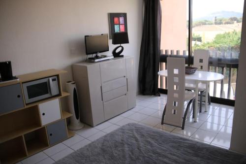 Il comprend un salon doté d'une télévision et d'une table avec un four micro-ondes. dans l'établissement Studio 216, Port Vénus au village naturiste, au Cap d'Agde