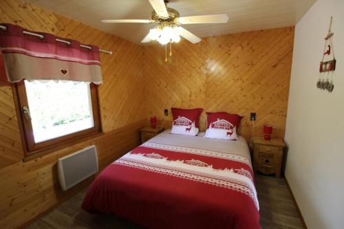 Schlafzimmer mit einem Bett und einem Deckenventilator in der Unterkunft Le Chalet du Cerf in Gerbépal