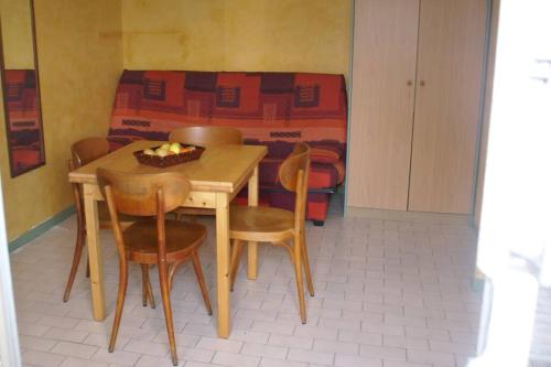 une table et des chaises dans une chambre avec un lit dans l'établissement Villa 12, Port Vénus au village naturiste, au Cap d'Agde