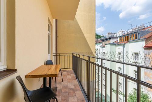a balcony with a wooden desk and a table and chairs at Petrin Tower Residence in Prague