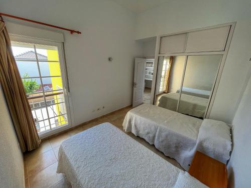 een slaapkamer met 2 bedden en een groot raam bij Villa Isabel in Adeje
