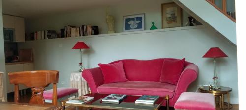 a living room with a red couch and a table at L'Orangerie White-Palacio in Versailles