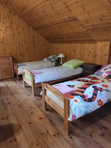 a room with three beds and a wooden ceiling at Stadnina koni Tarka in Zwierzyniec