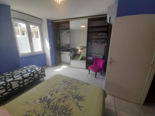 uma sala com um quarto com uma cama e uma cadeira em Au 70 em Millau