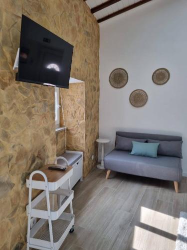 a living room with a couch and a flat screen tv at Casa do Judas in Alvares
