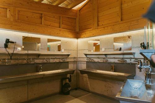 a bathroom with two sinks and two mirrors at Ca Stella Camping del Monte San Giorgio in Meride