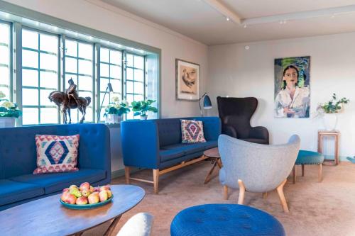 a living room with blue couches and a table at Green Hotel in Tällberg