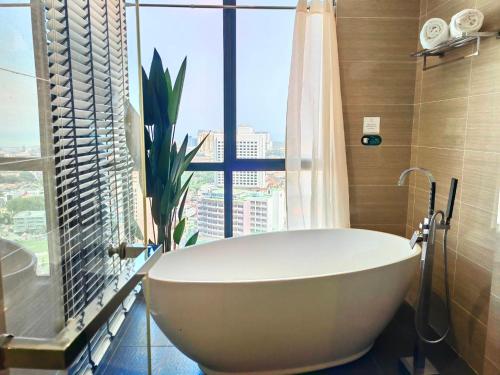 a bath tub in a bathroom with a large window at The Honeymoon Haven - 99 Residences in Melaka