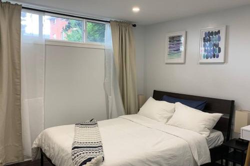 1 dormitorio con cama blanca y ventana en *Cozy, newly renovated, fully equipped* en Hamilton