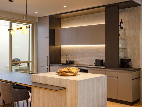 a kitchen with a table with a bowl of fruit on it at South Beach Camps Bay Boutique Hotel in Cape Town