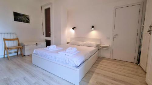 a white bedroom with a white bed and a chair at Sea Breeze - Barcola - Trieste Reception in Trieste