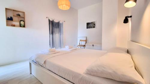 una camera bianca con un letto e una sedia di Sea Breeze - Barcola a Trieste
