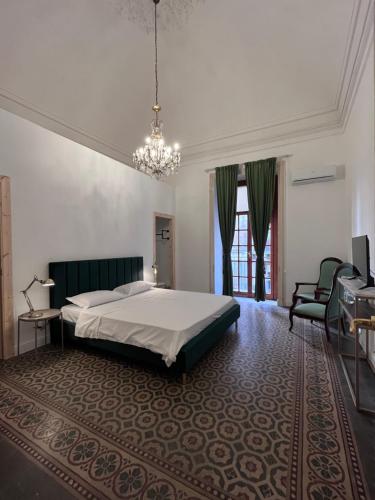 a bedroom with a bed and a chandelier at Beretti Home in Catania