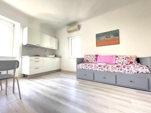 a white room with a bed and a kitchen at Koper Relax home in Koper