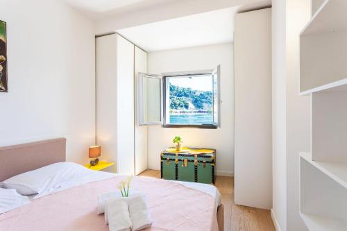 a small bedroom with two beds and a window at LA RESERVE AP4369 By Riviera Holiday Homes in Villefranche-sur-Mer