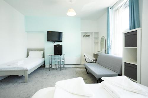 a room with two beds and a couch and a tv at The Sea Lynn in Morecambe