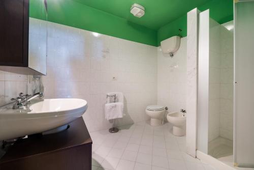 a bathroom with a sink and a toilet and green ceiling at Certosa di Pontignano Residenza d'Epoca - Place of Charme in Ponte A Bozzone