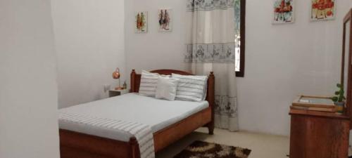 a bedroom with a bed with white sheets and pillows at Vero house in Zanzibar City