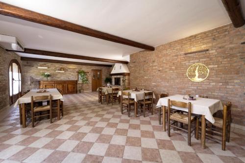 博沃倫塔的住宿－La Tenuta Va Oltre，一间带桌椅的餐厅以及砖墙