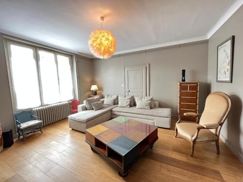 uma sala de estar com um sofá e uma mesa em Le Roadtrip- Maison - Jardin - Tramway - 8p em Le Mans