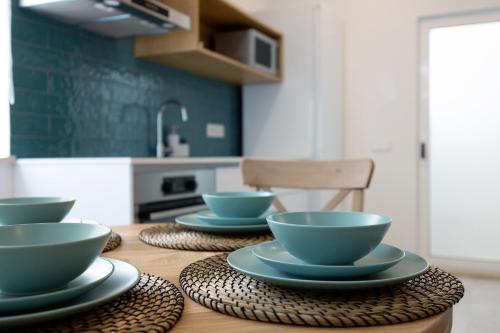 a wooden table with blue bowls and plates on it at Old Town Apartments City in Lagos