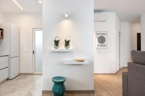 a living room with white walls and a blue stool at Old Town Apartments City in Lagos