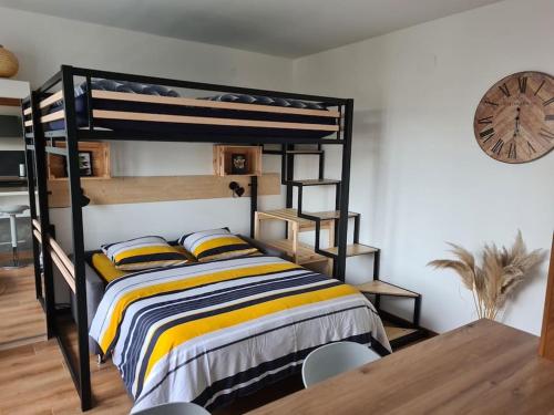 ein Schlafzimmer mit einem Etagenbett und einem Holztisch in der Unterkunft Studio cosy et lumineux bike parking in Saverne