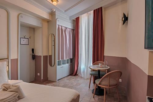 a hotel room with a bed and a table and chairs at Aparthotel AMMI Vieux Nice in Nice