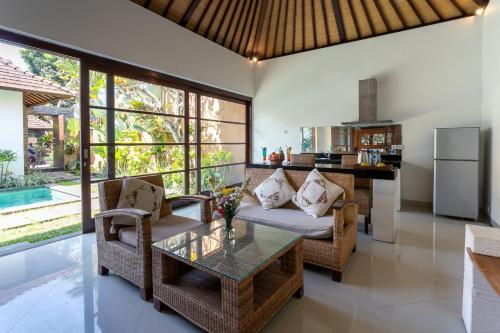 una cucina e un soggiorno con tavolo e sedie di Sukanami Villa Ubud by ecommerceloka a Gianyar