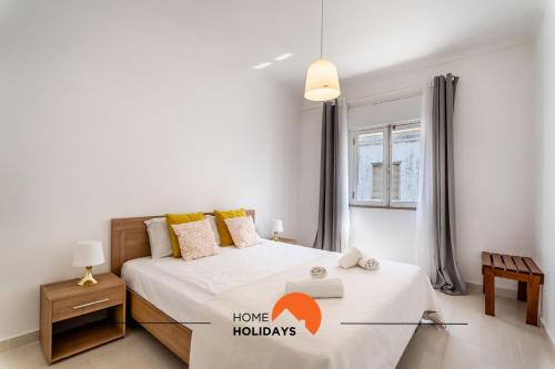 una camera bianca con un letto e una finestra di #162 Old Town Open Space with Balcony 120 mts Beach ad Albufeira