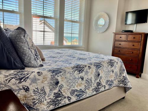 a bedroom with a bed and a dresser and windows at SC302 - C-View in Kill Devil Hills