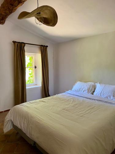 une chambre avec un grand lit et une fenêtre dans l'établissement charmant appartement indépendant au sein d'un mas provençal, à Aups