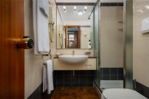 uma casa de banho com um lavatório e um espelho em Hotel Crivi's em Milão